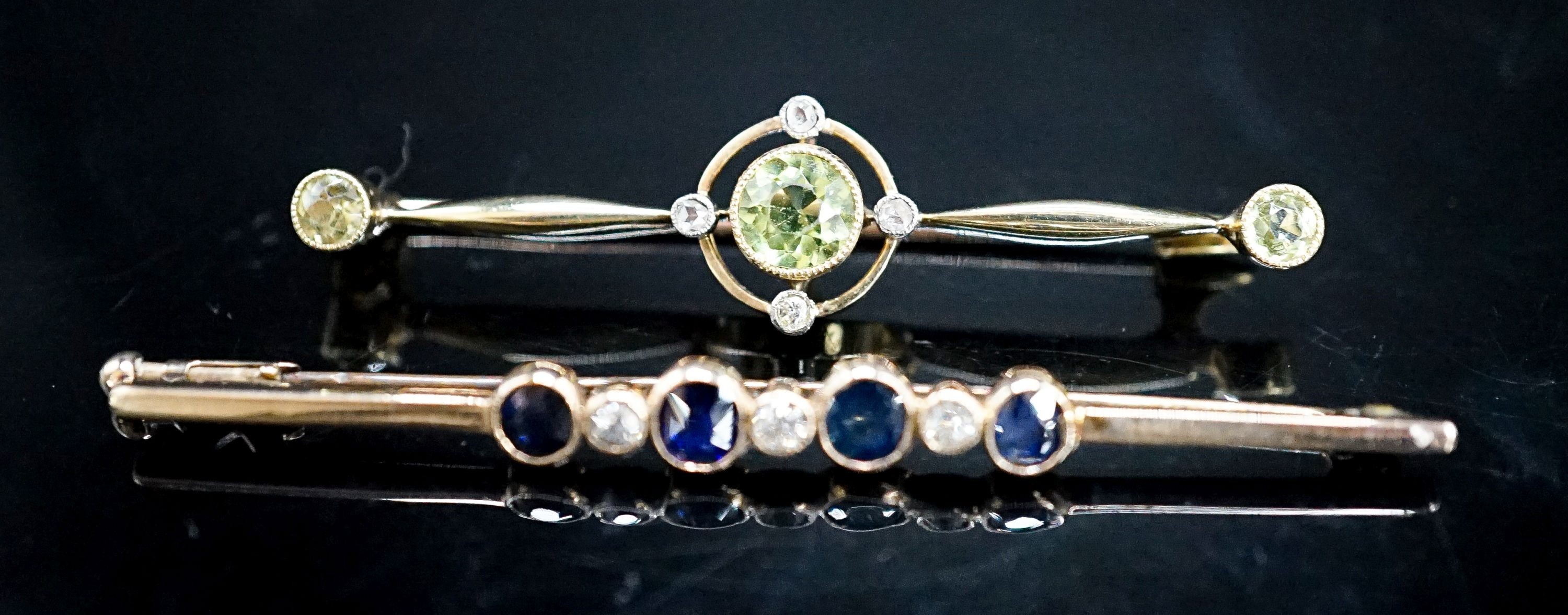 An Edwardian 15ct, peridot and diamond set bar brooch, 49mm, gross weight 4.4 grams and a yellow metal, sapphire and diamond set seven stone bar brooch, gross 3 grams